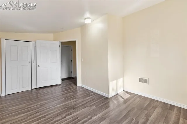 a view of an empty room with wooden floor