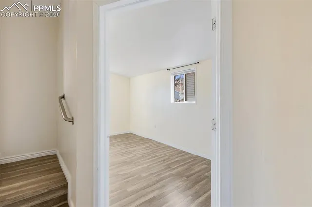 a view of a hallway with wooden floor