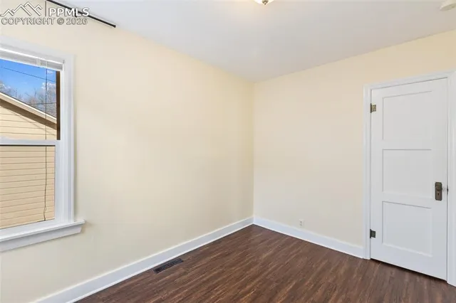 a view of a small space with wooden floor and a window