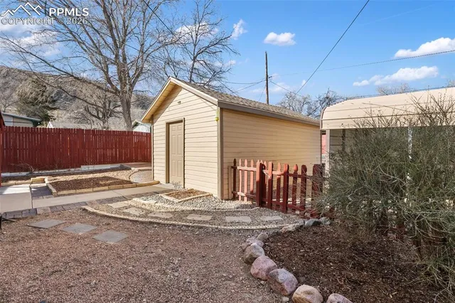 a view of a house with backyard and wooden fence