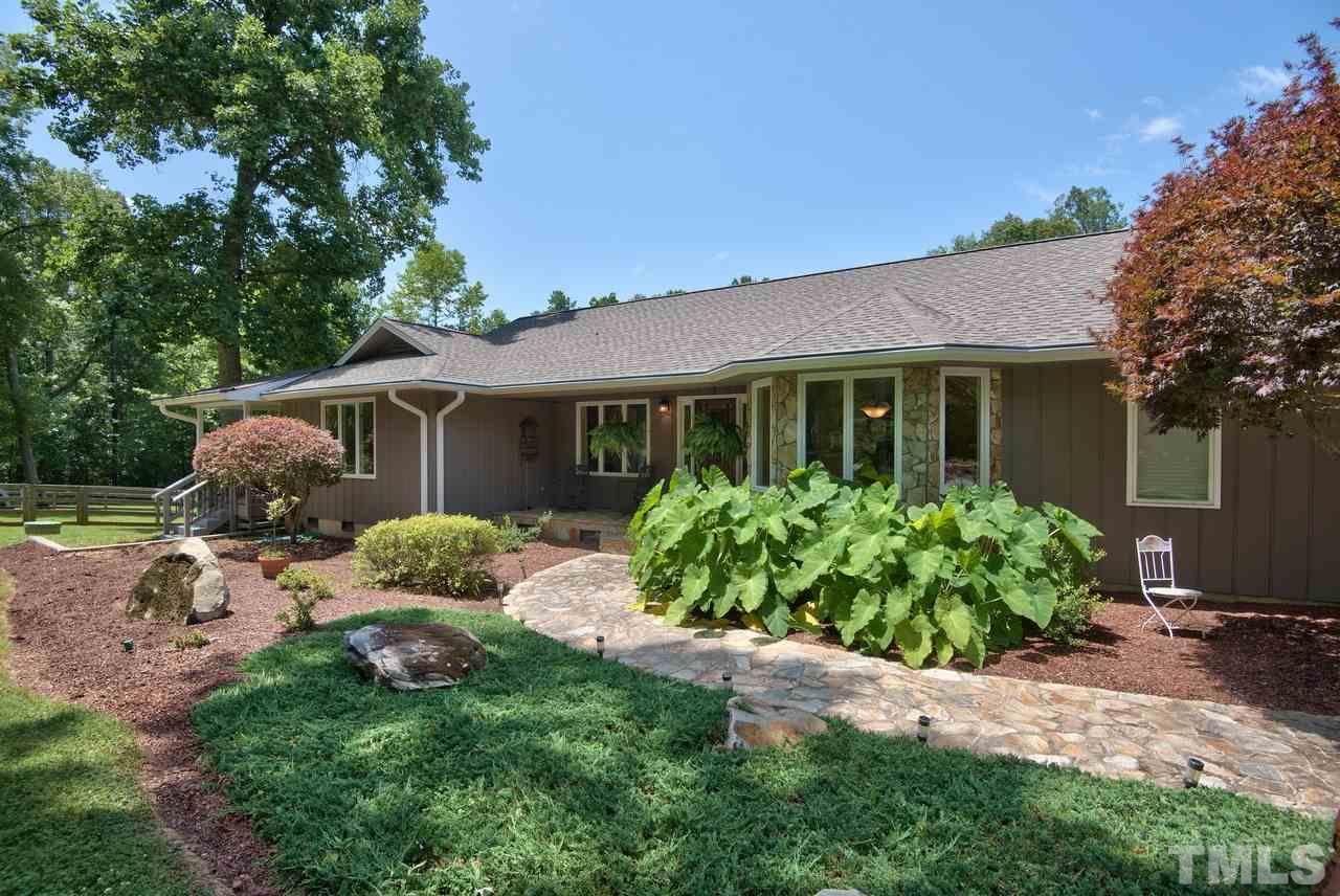 718 Patrick Road Bahama, NC 27503 - Photo 14 of 25 a front view of a house with a garden