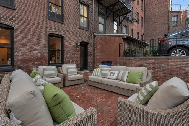 a view of a patio with couches and a fireplace