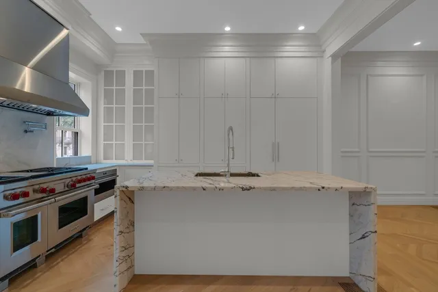 a view of kitchen island with stainless steel appliances wooden floor and window