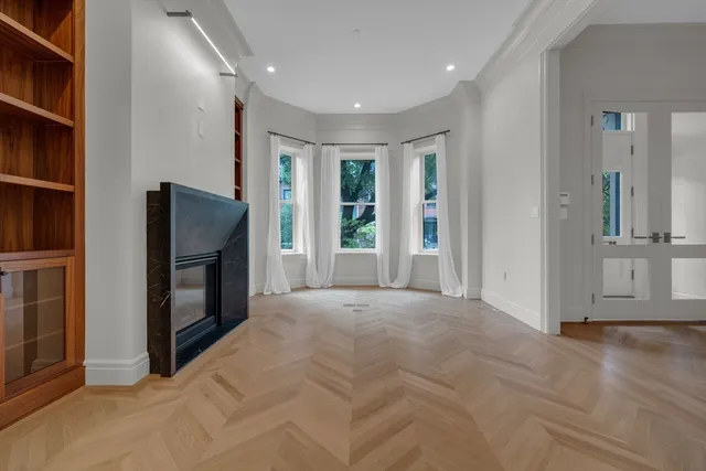a view of an empty room with a fireplace and a window