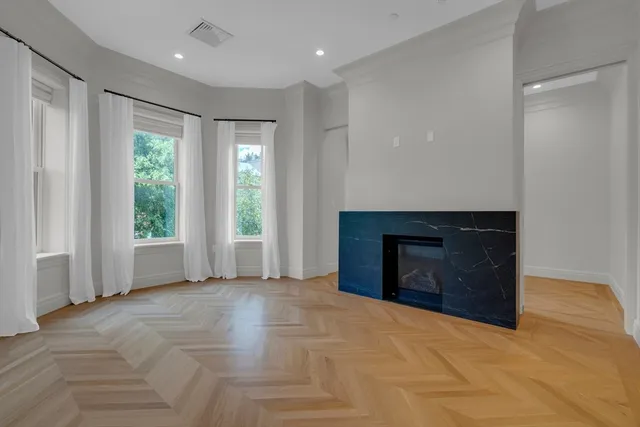 a view of an empty room with a fireplace and a window