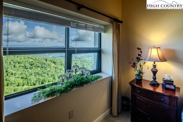 a bedroom with a bed a flat screen tv and a window