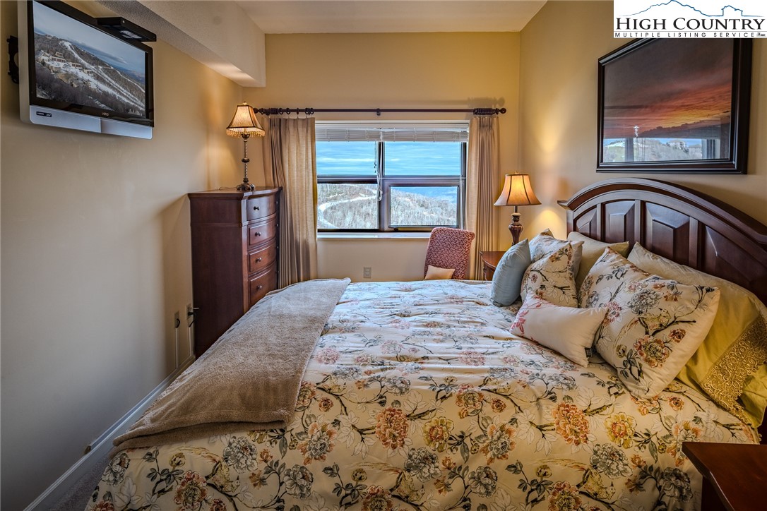 303 Sugar Top Drive, Unit 43427 Sugar Mountain, NC 28604 - Photo 13 of 18 a bedroom with a bed and a painting on the wall