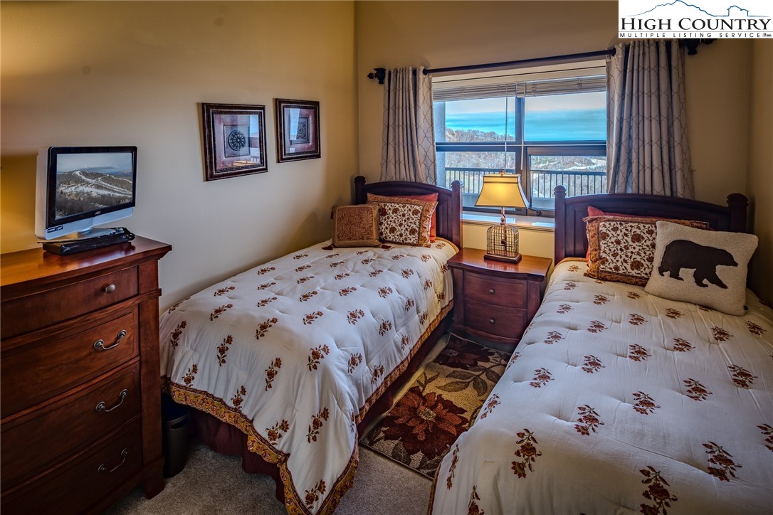 303 Sugar Top Drive, Unit 43427 Sugar Mountain, NC 28604 - Photo 15 of 18 a bedroom with a bed and wooden floor