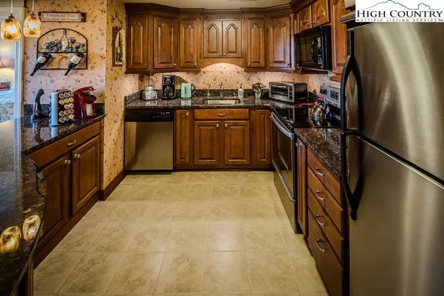 a kitchen with granite countertop a sink a stove and cabinets