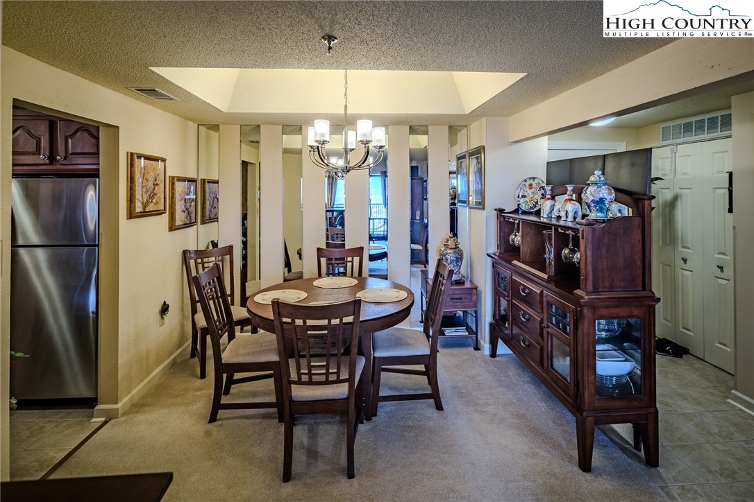 303 Sugar Top Drive, Unit 43427 Sugar Mountain, NC 28604 - Photo 7 of 18 a view of a dining room with furniture and chandelier