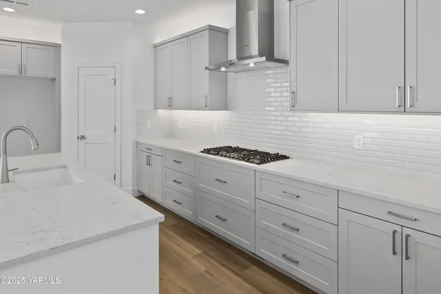 a large kitchen with kitchen island a sink dishwasher a stove and a refrigerator with wooden floor