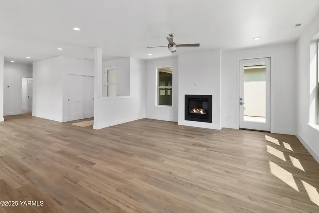 a large white kitchen with a refrigerator a kitchen island a stove and a wooden floors