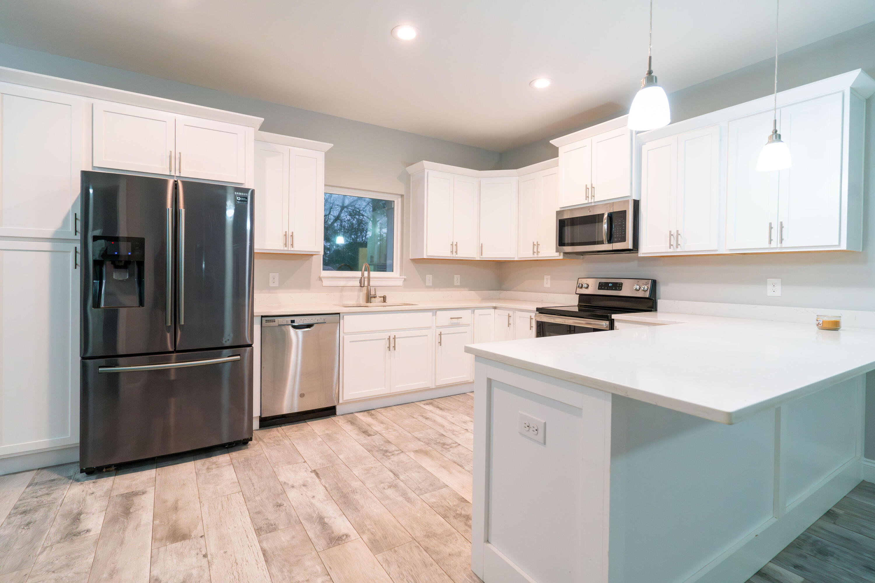 2243 Wind Trace Road North Navarre, FL 32566 - Photo 9 of 34 a kitchen with kitchen island a refrigerator sink and cabinets