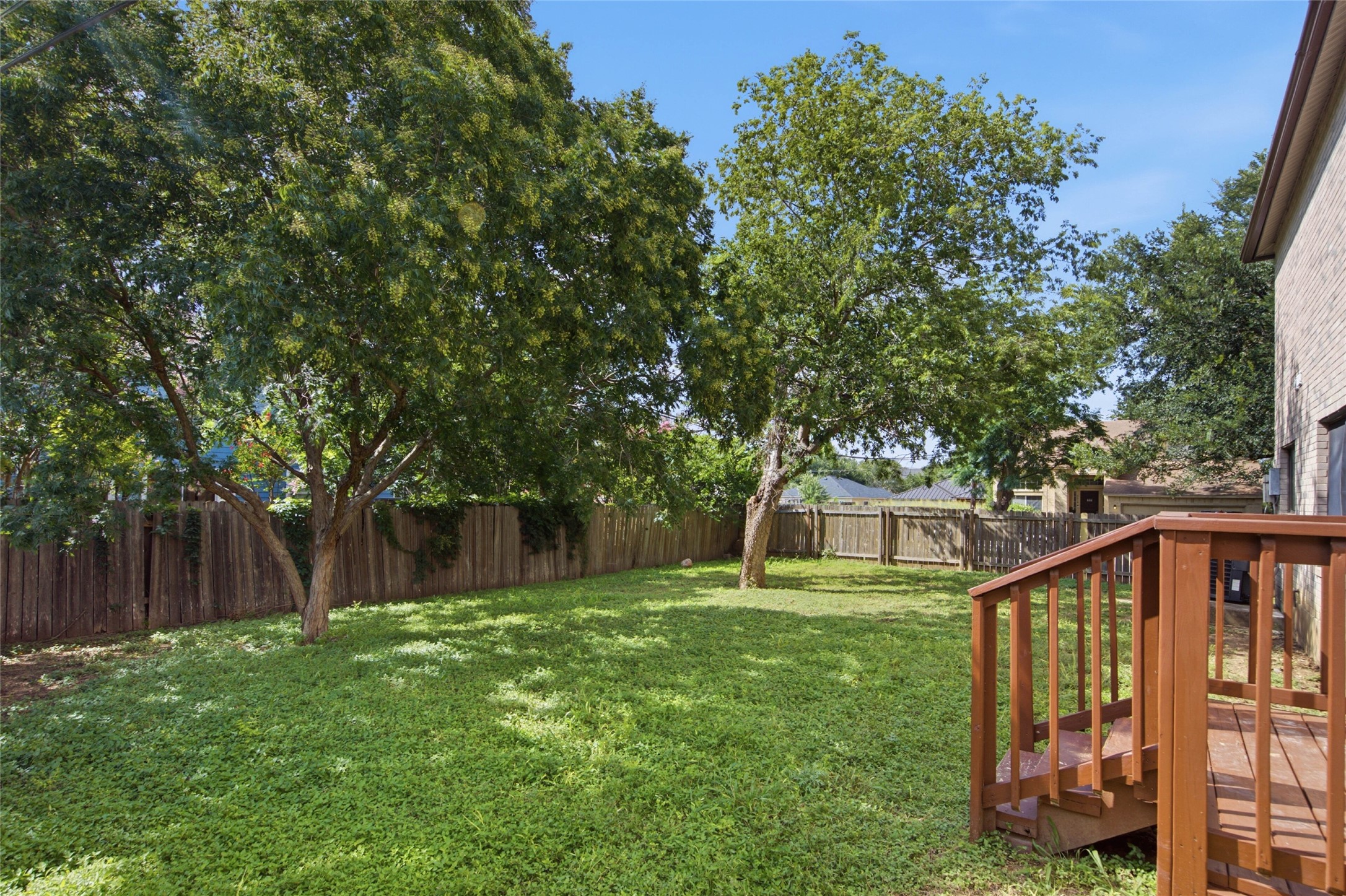 7900 Rosenberry Drive Austin, TX 78747 - Photo 24 of 27 A generously sized yard, complete with mature shade trees and a wooden privacy fence, provides ample space for outdoor enjoyment.