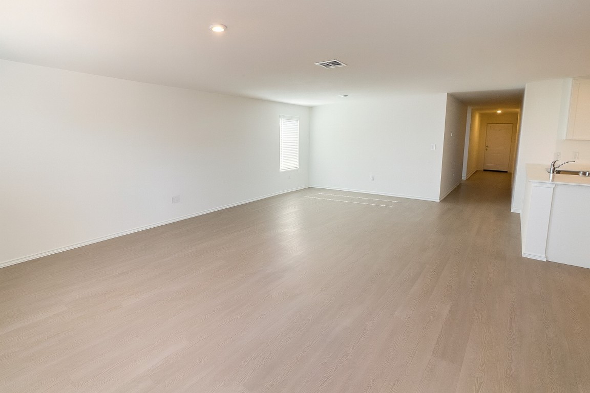 461 Whoopers Loop Uhland, TX 78640 - Photo 2 of 12 an empty room with wooden floor and windows