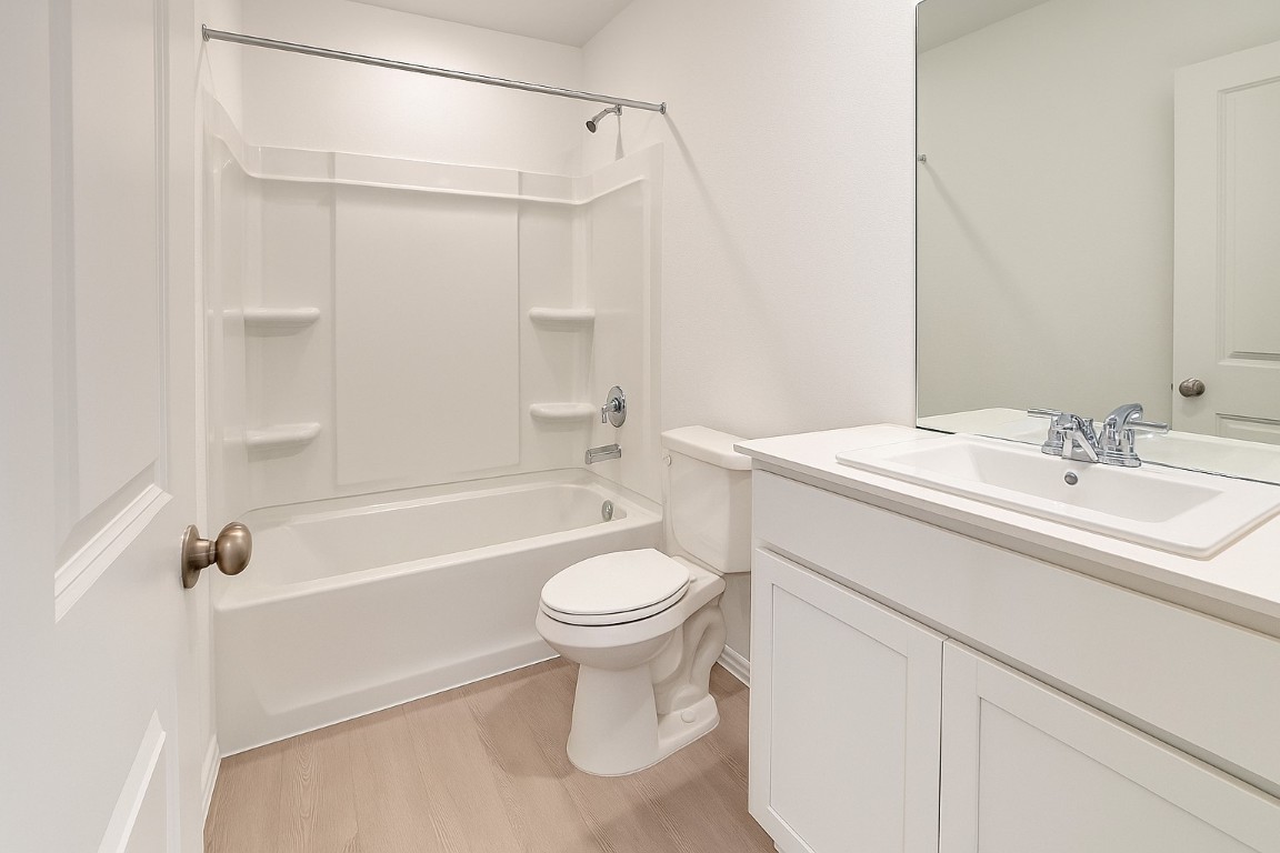 461 Whoopers Loop Uhland, TX 78640 - Photo 7 of 12 a bathroom with a sink a toilet and a bathtub