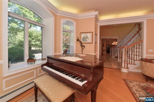 a living room with a couch a table and large windows with wooden floor