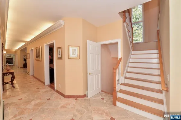 a view of a hallway with entryway wooden floor and windows