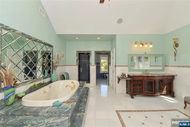 a spacious bathroom with a tub and chandelier