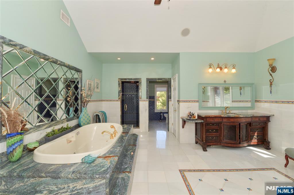 14 Werimus Brook Road Saddle River, NJ 07458 - Photo 35 of 50 a spacious bathroom with a tub and chandelier