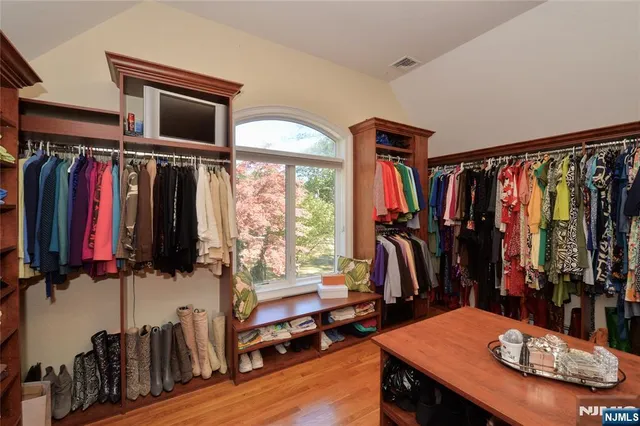 a view of walk in closet with clothes and shoes