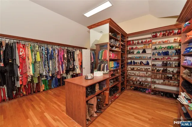 a view of walk in closet with clothes and shoes