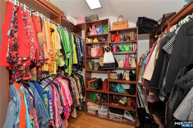 a view of walk in closet with clothes and shoes