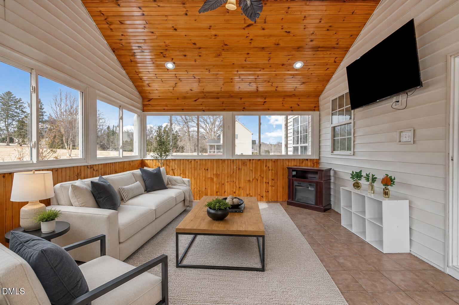 51 Water Front Lane Timberlake, NC 27583 - Photo 15 of 29 a living room with furniture a flat screen tv and a floor to ceiling window