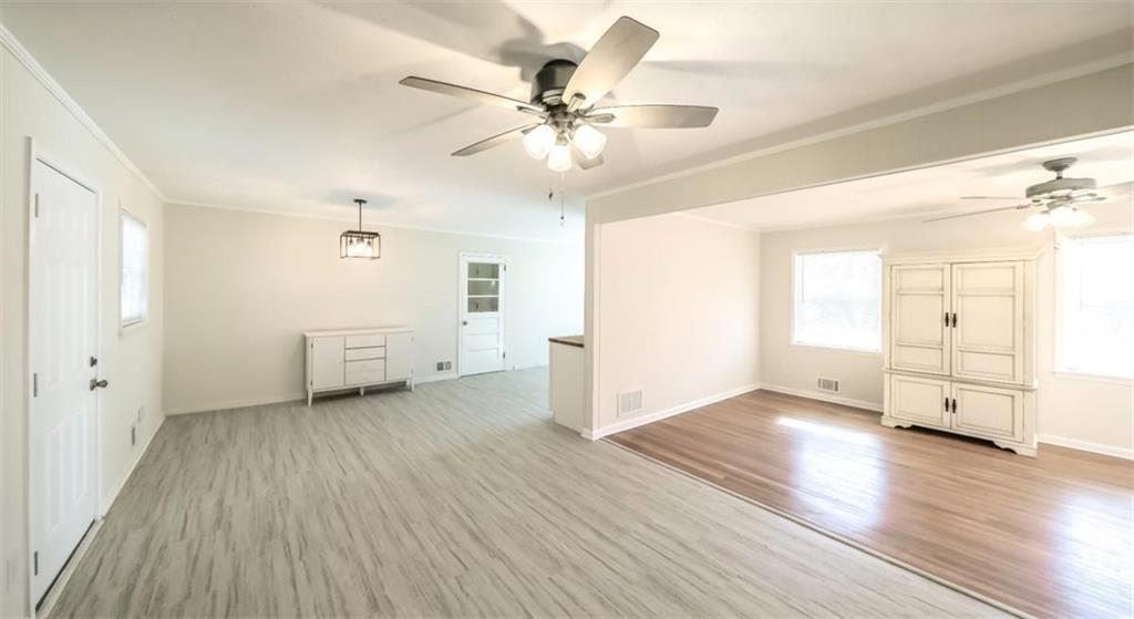 4045 Compton Circle Powder Springs, GA 30127 - Photo 41 of 54 an empty room with wooden floor a ceiling fan and windows