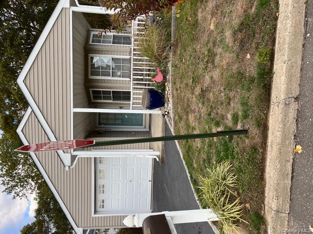 a view of a white house with a small yard and large window
