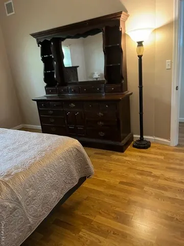 a bedroom with a bed and a mirror on dresser