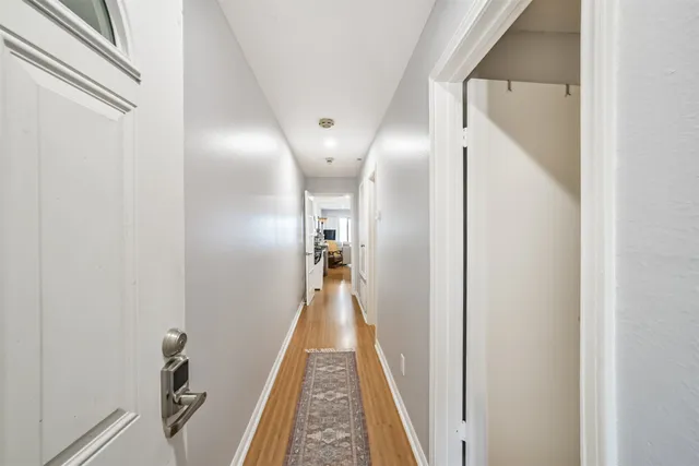 a view of a hallway with wooden floor and staircase