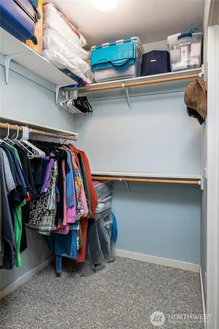 a view of walk in closet with clothes and shoes