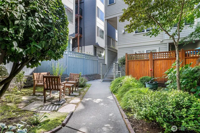 a view of a patio with table and chairs potted plants and large tree