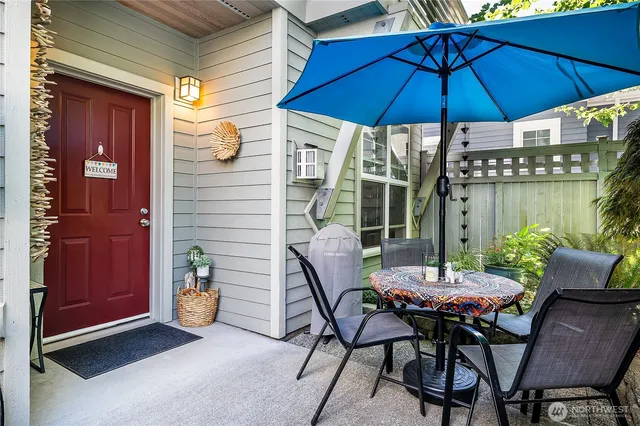 a view of a patio with a table and chairs under an umbrella