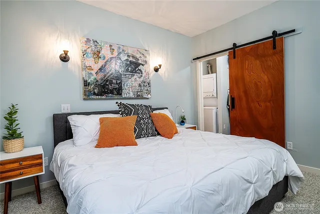 a bedroom with a bed and painting on the wall