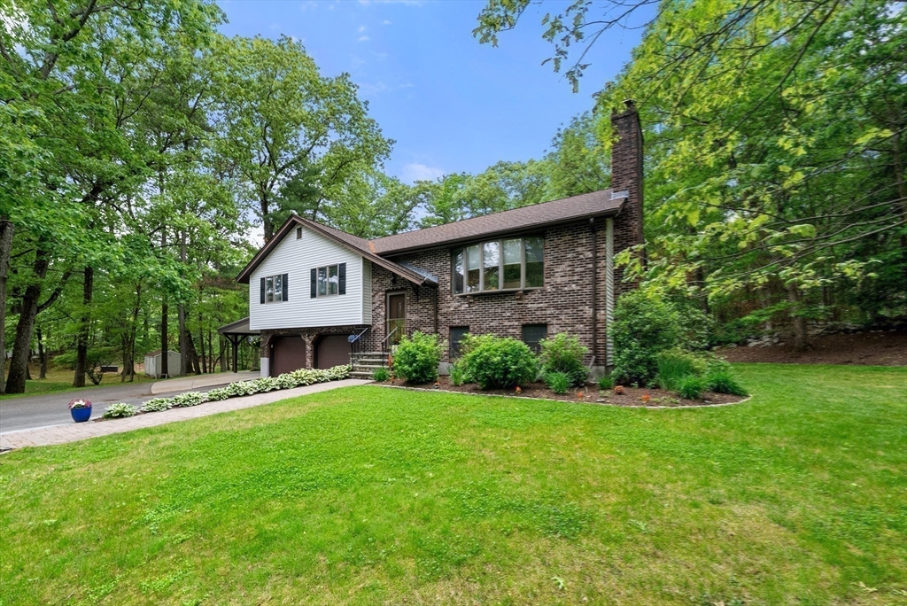 a front view of a house with a yard and trees