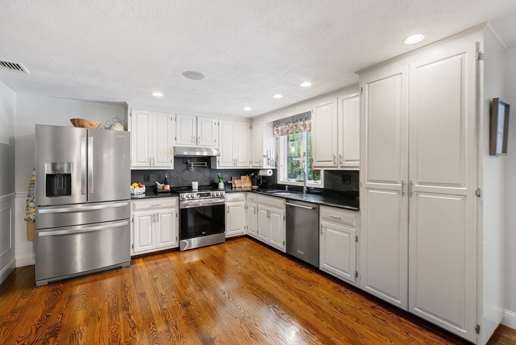 12 Nancy Road Natick, MA 01760 - Photo 3 of 25 a kitchen with stainless steel appliances granite countertop a refrigerator and a stove top oven