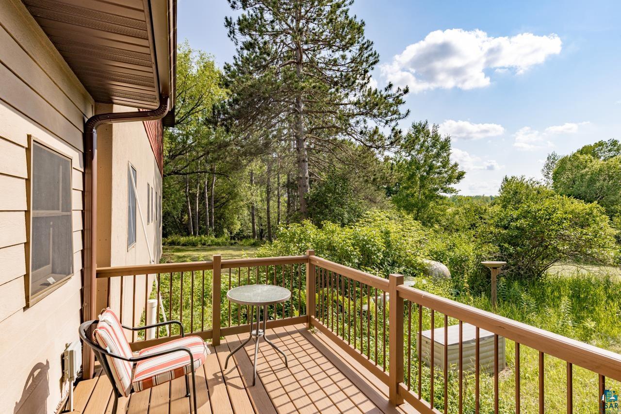 4800 Tower Road Moose Lake, MN 55767 - Photo 54 of 83 Wood-finish deck with a brown railing overlooking a natural green landscape