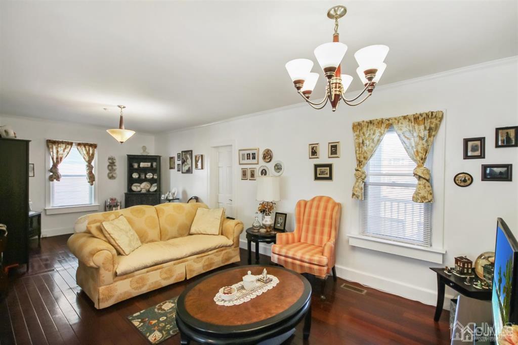 122 South Lincoln Avenue Middlesex, NJ 08846 - Photo 2 of 37 a living room with fireplace chandelier and a wooden floor