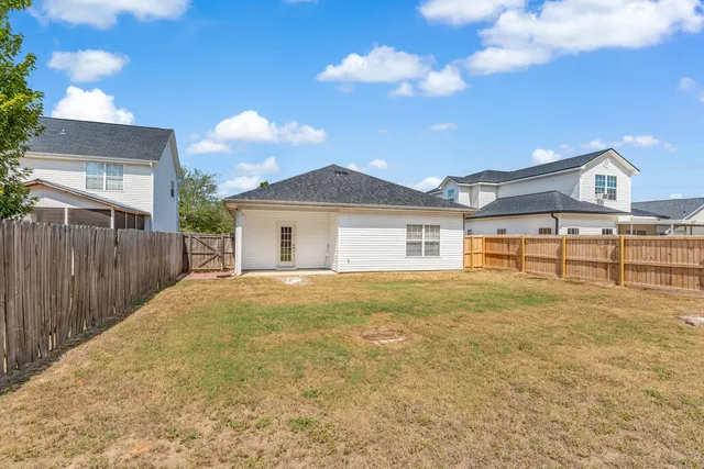 a view of a yard in front of a house with a large tree