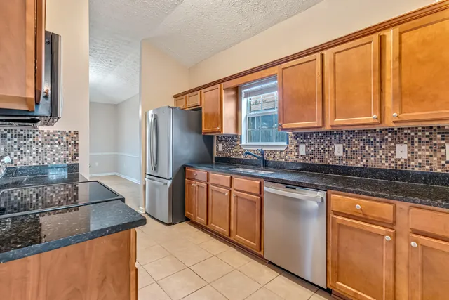a kitchen with stainless steel appliances granite countertop a refrigerator and a sink