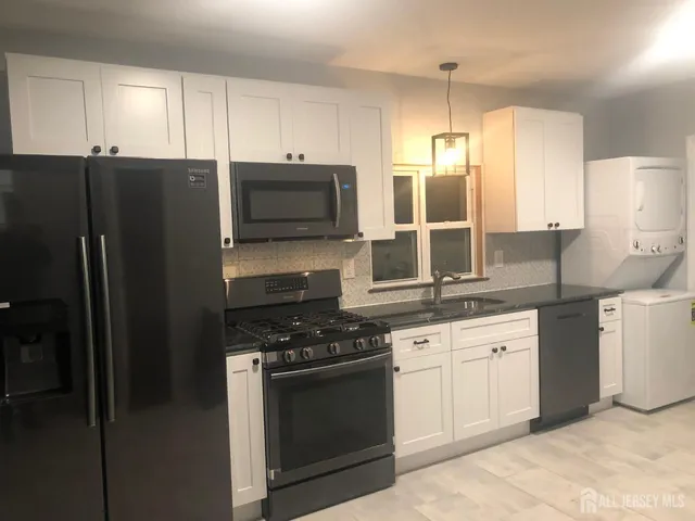 a kitchen with stainless steel appliances granite countertop a refrigerator stove and sink