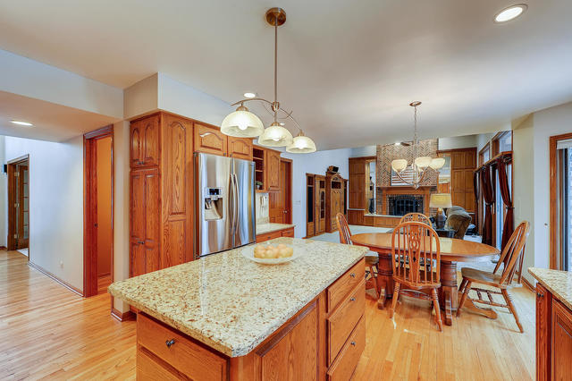 125 Briargate Road Cary, IL 60013 - Photo 4 of 24 an open kitchen with dining table and wooden floor