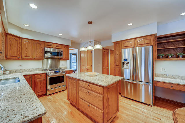 125 Briargate Road Cary, IL 60013 - Photo 5 of 24 a kitchen with granite countertop stainless steel appliances and wooden cabinets