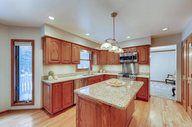 125 Briargate Road Cary, IL 60013 - Photo 6 of 24 a kitchen with stainless steel appliances granite countertop a sink a stove and a wooden floors