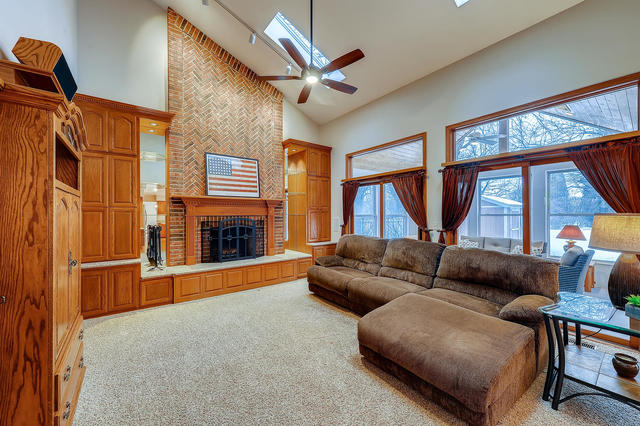 125 Briargate Road Cary, IL 60013 - Photo 8 of 24 a living room with furniture a ceiling fan a fireplace and a large window