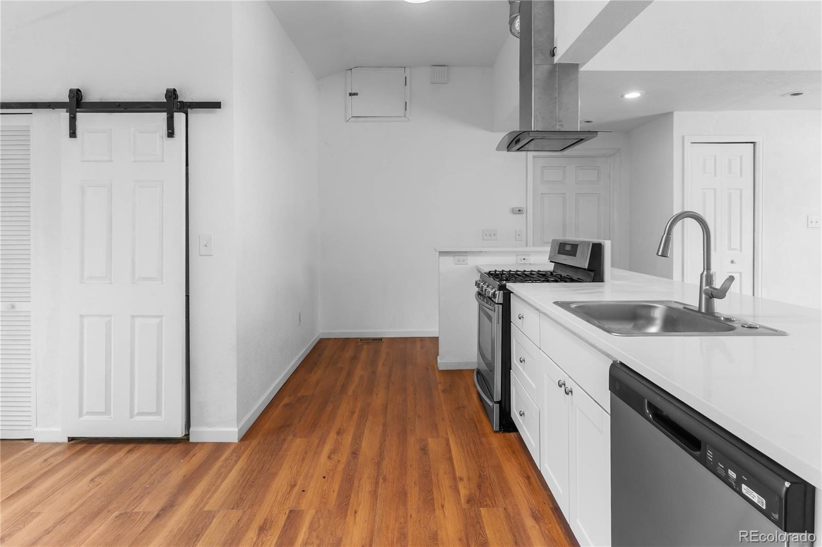 7010 West 44th Avenue Wheat Ridge, CO 80033 - Photo 8 of 31 a view of a kitchen with a sink and wooden floor