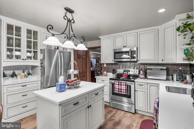 a kitchen with kitchen island granite countertop white cabinets and white appliances