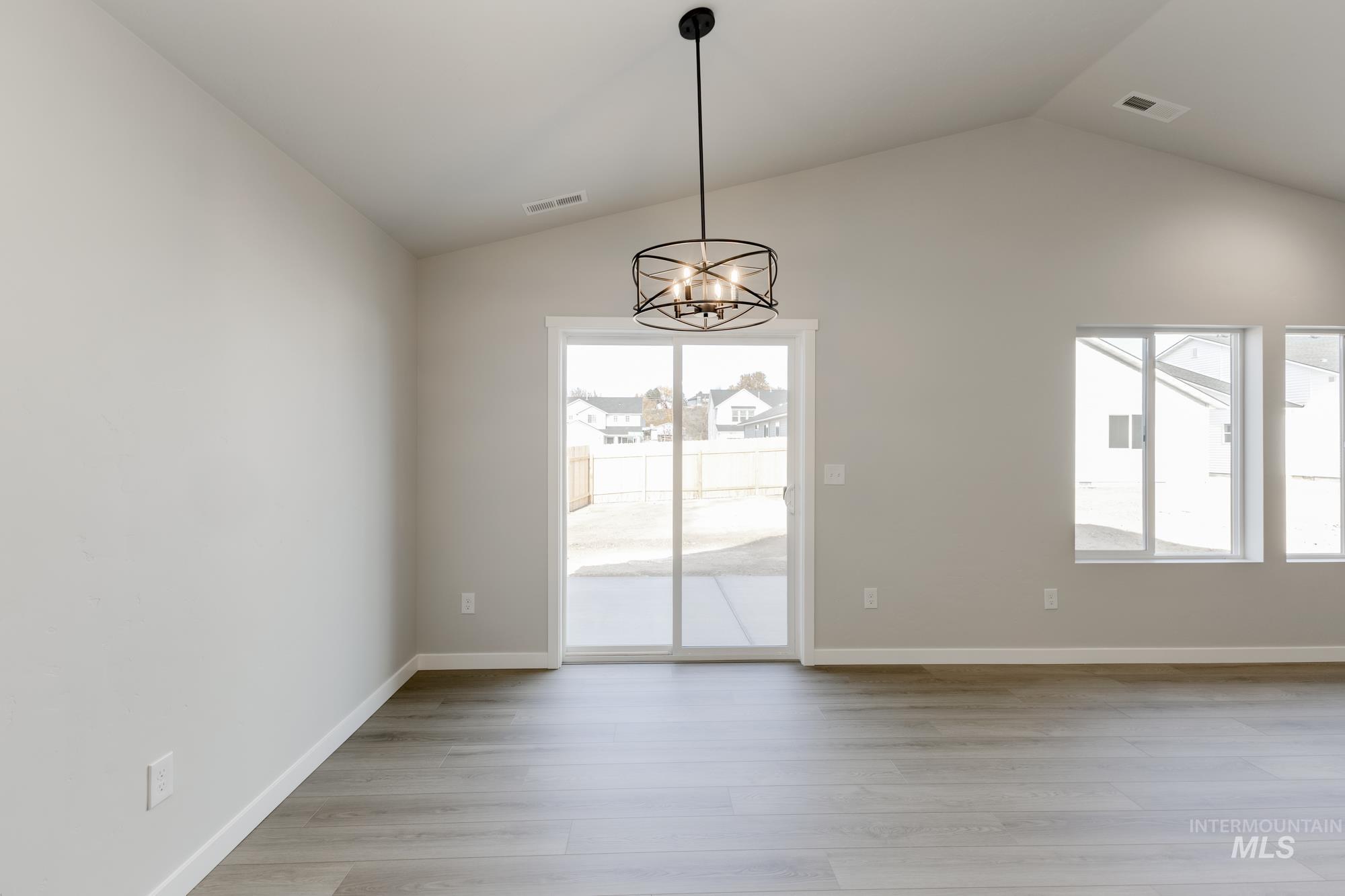 1804 West Unforgettable Street Meridian, ID 83642 - Photo 6 of 18 Unfurnished dining area featuring lofted ceiling, a chandelier, and light wood finished floors